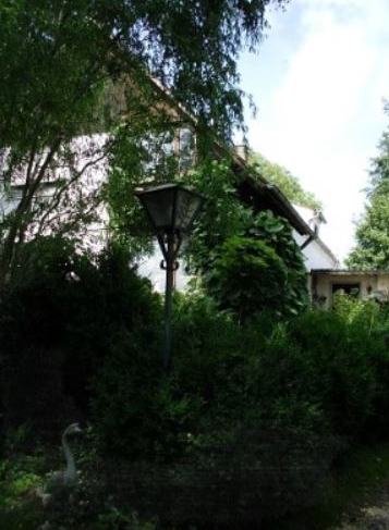 Blick durch den Garten auf das Haus mit alter Laterne.